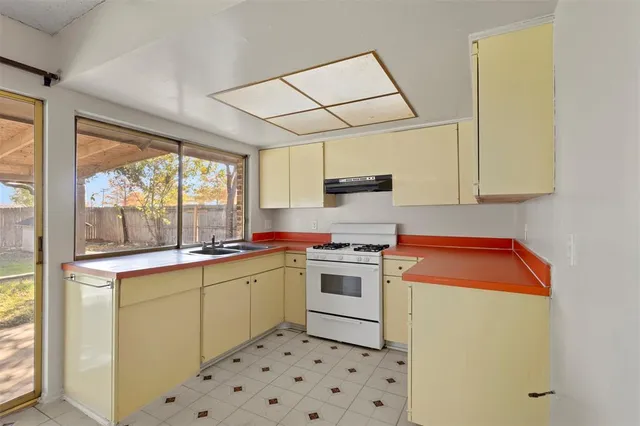 a kitchen with a stove a sink and a refrigerator