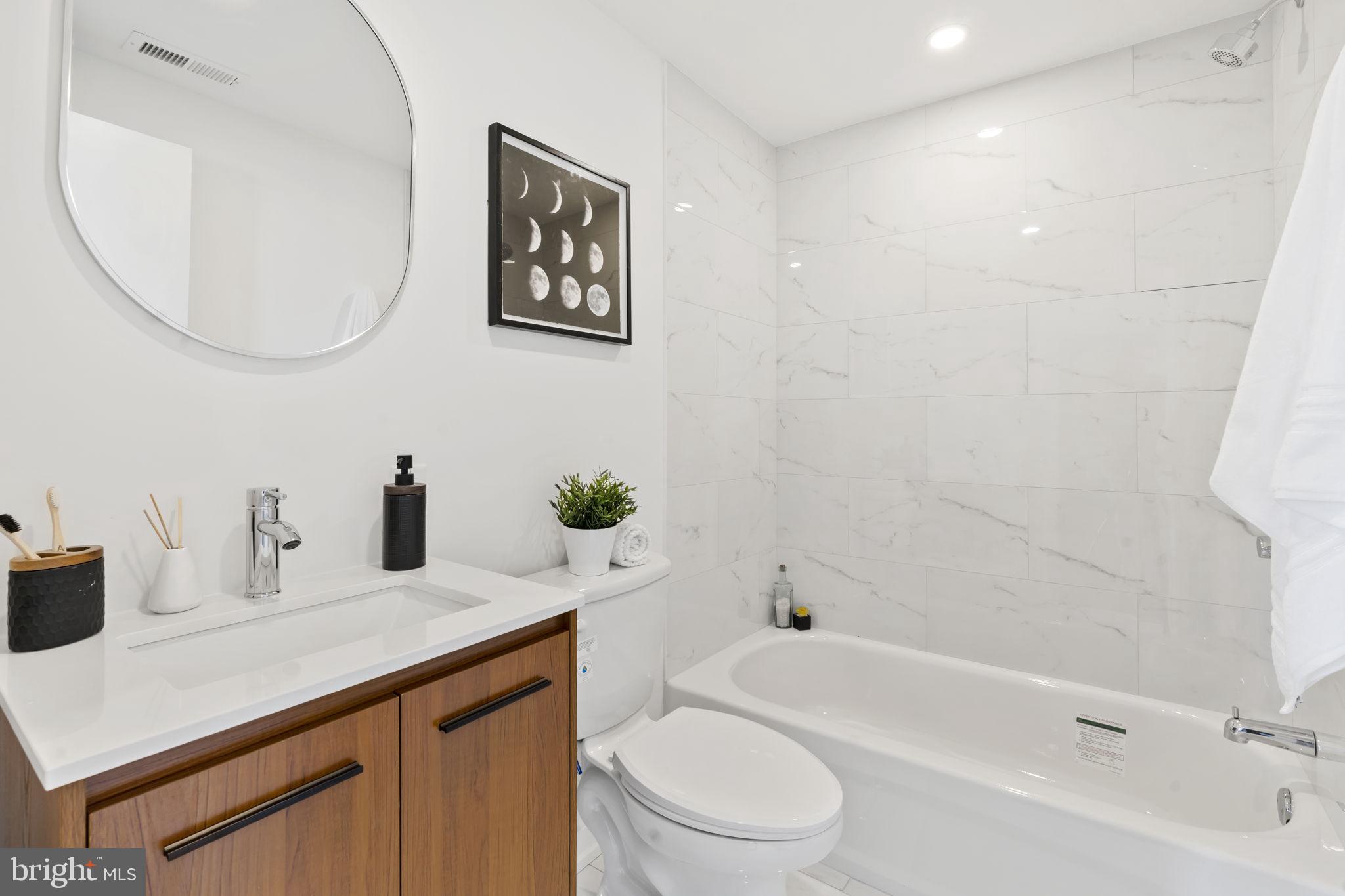 240 Hermitage Street, Unit 202 Philadelphia, PA 19127 - Photo 14 of 23 a bathroom with a sink a toilet and a mirror