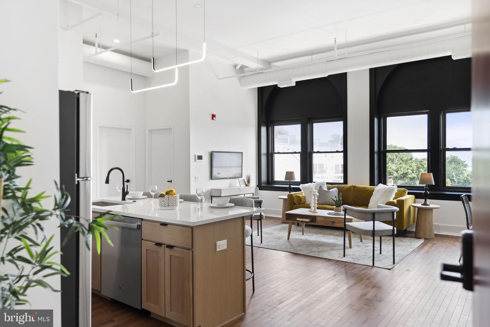 240 Hermitage Street, Unit 202 Philadelphia, PA 19127 - Photo 5 of 23 a living room with stainless steel appliances kitchen island granite countertop a stove a sink and a large window