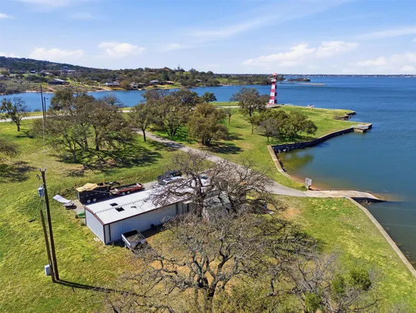 an aerial view of a house with a yard and lake view