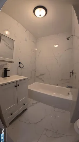 a bathroom with a tub sink and mirror