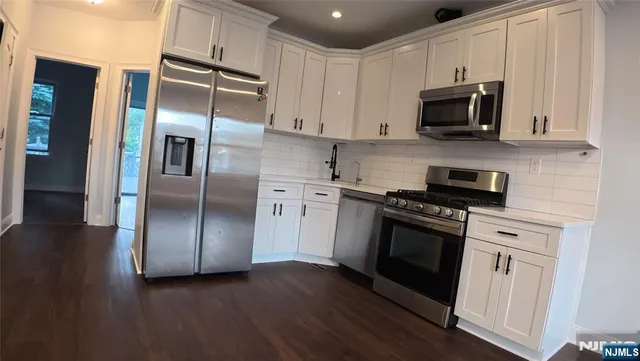 a kitchen with stainless steel appliances and wooden floor