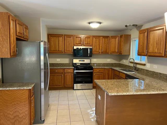 a kitchen with granite countertop a stove top oven and cabinets