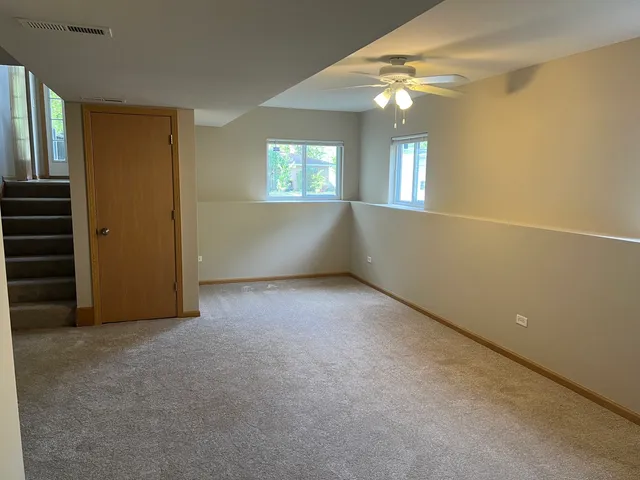 an empty room with windows and fan