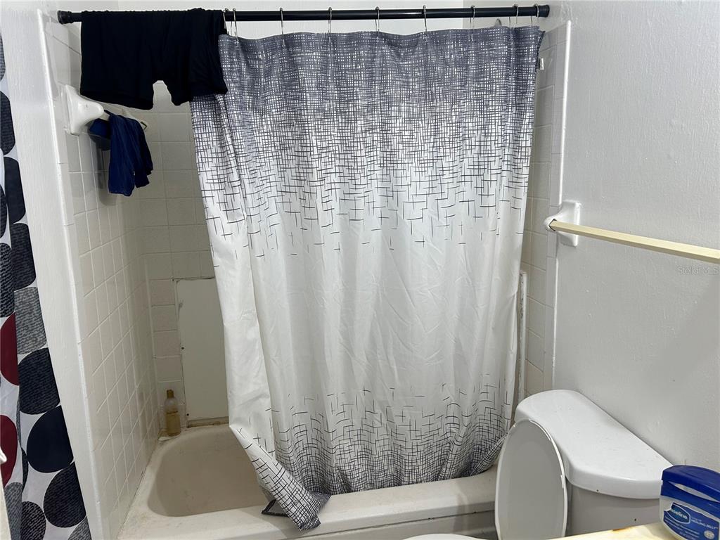 5391 Botany Court Orlando, FL 32811 - Photo 6 of 11 a bathroom with a shower curtain and a window