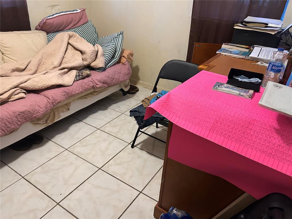 5391 Botany Court Orlando, FL 32811 - Photo 7 of 11 a bedroom with a bed and a potted plant