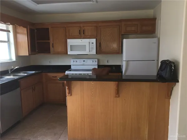 a kitchen with stainless steel appliances granite countertop a refrigerator a sink a stove and dishwasher