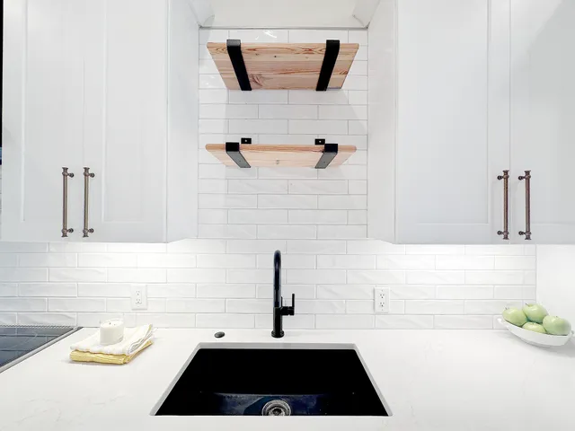 a kitchen with stainless steel appliances kitchen island granite countertop a sink and refrigerator