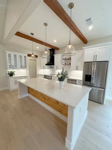a view of a hallway with an empty room and wooden floor