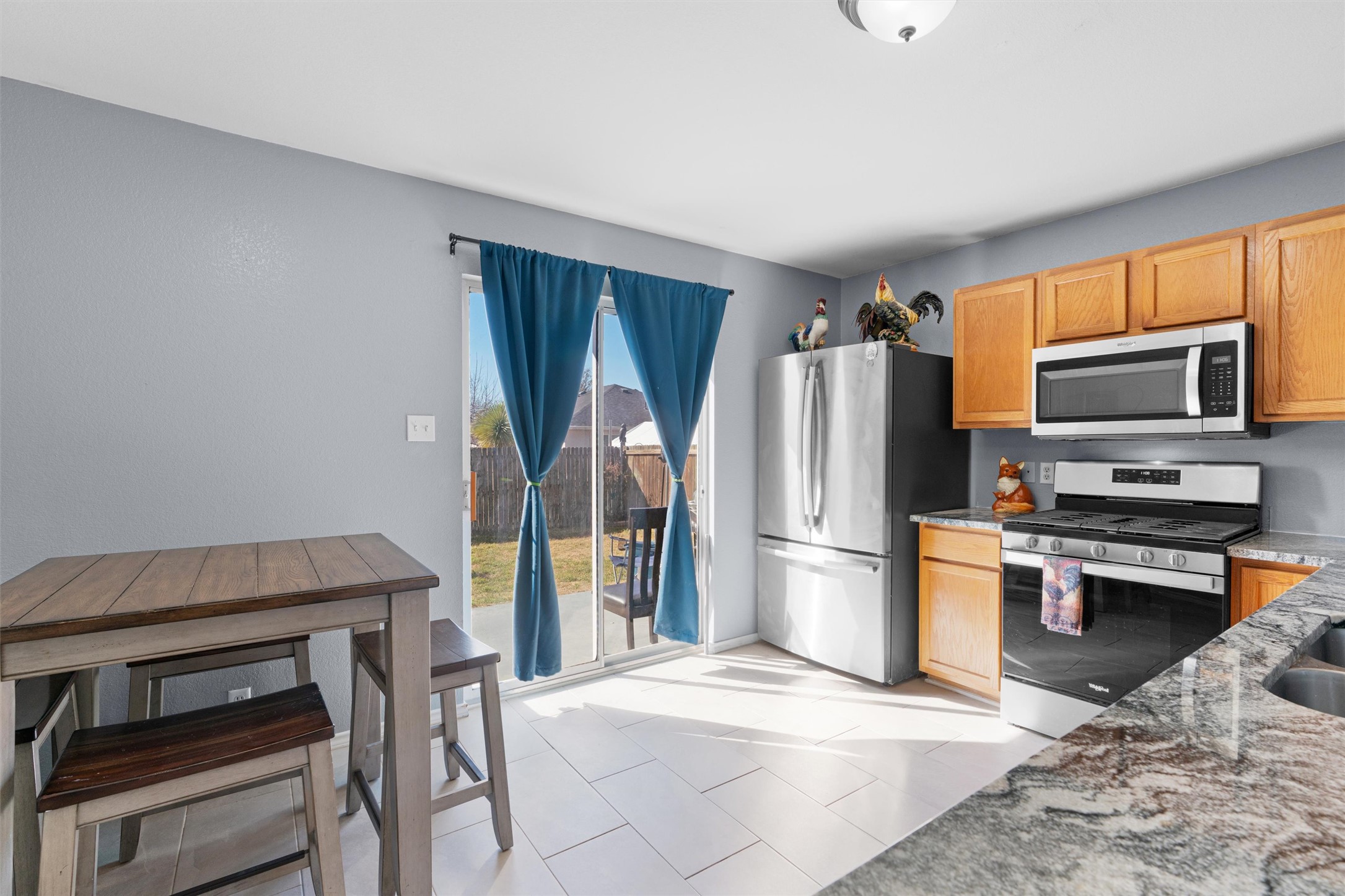 128 Steven Street Hutto, TX 78634 - Photo 7 of 29 a kitchen with a refrigerator and a stove top oven