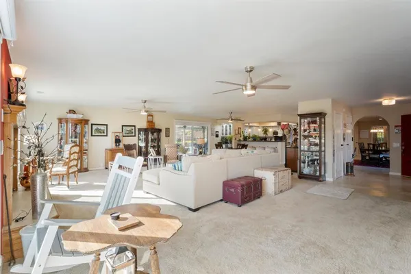 a living room with furniture a fireplace and a kitchen view