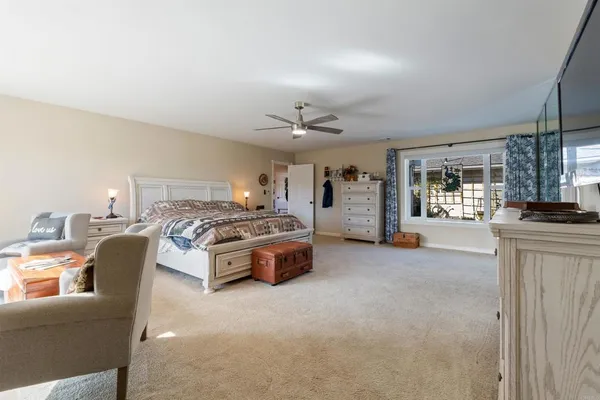 a spacious bedroom with a bed a couch and dresser