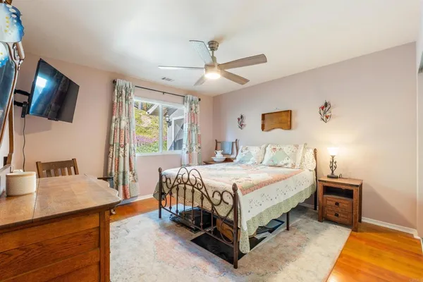 a bedroom with a bed a flat screen tv and a chandelier