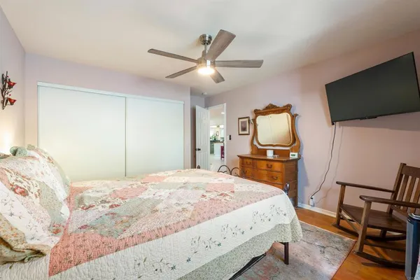 a bedroom with a bed a mirror on dresser and a chandelier