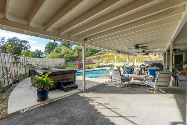 a view of a patio with table and chairs potted plants with wooden floor and fence