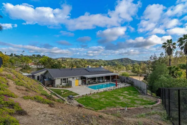 a view of a big house with a big yard and large trees