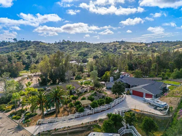 an aerial view of residential houses with outdoor space and trees