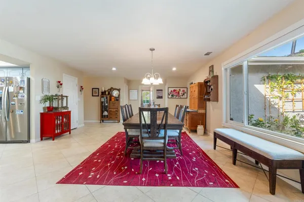 a living room with furniture a table and kitchen view