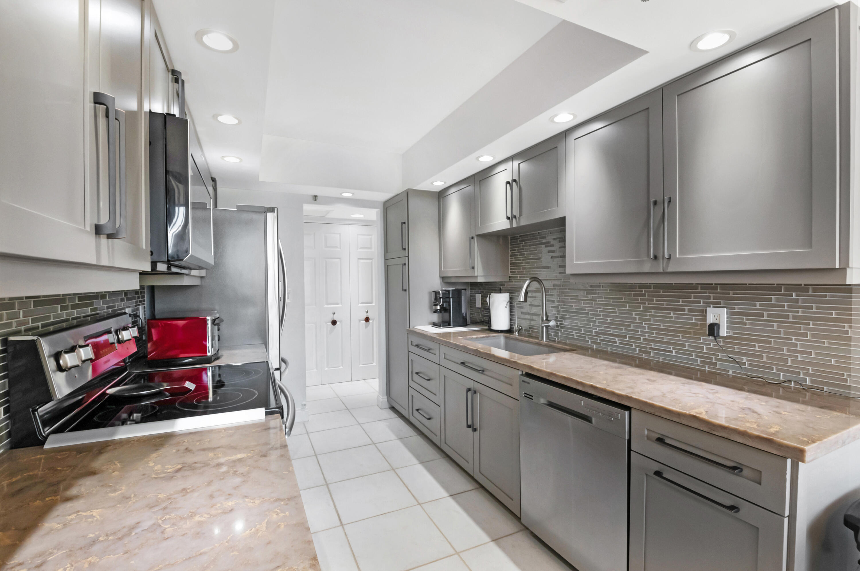 20100 Boca W Drive, Unit 126 Boca Raton, FL 33434 - Photo 12 of 58 a kitchen with kitchen island granite countertop a sink stainless steel appliances and cabinets