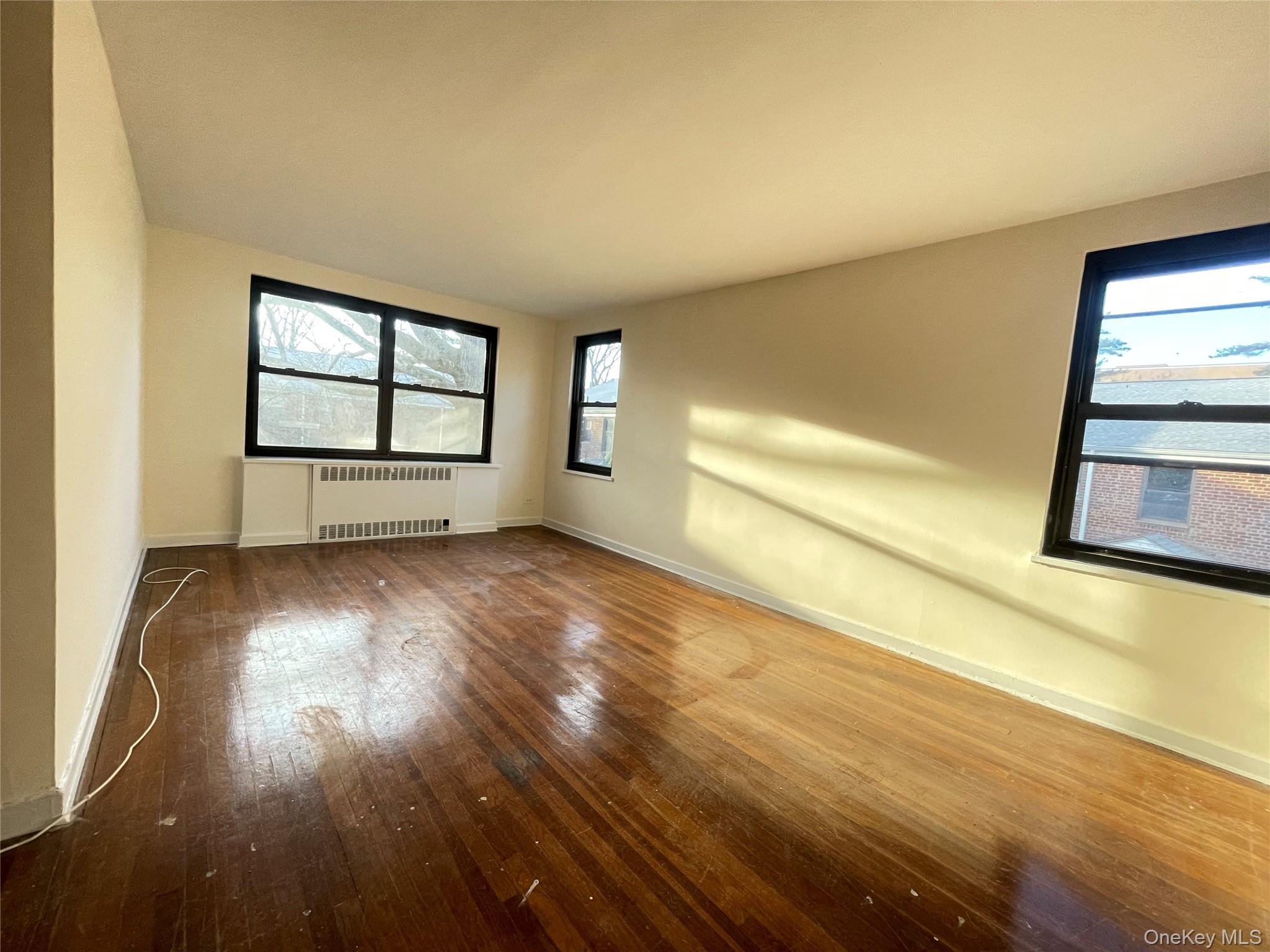 141 East Hartsdale Avenue, Unit 2A Hartsdale, NY 10530 - Photo 5 of 24 Spare room with radiator heating unit and hardwood / wood-style floors