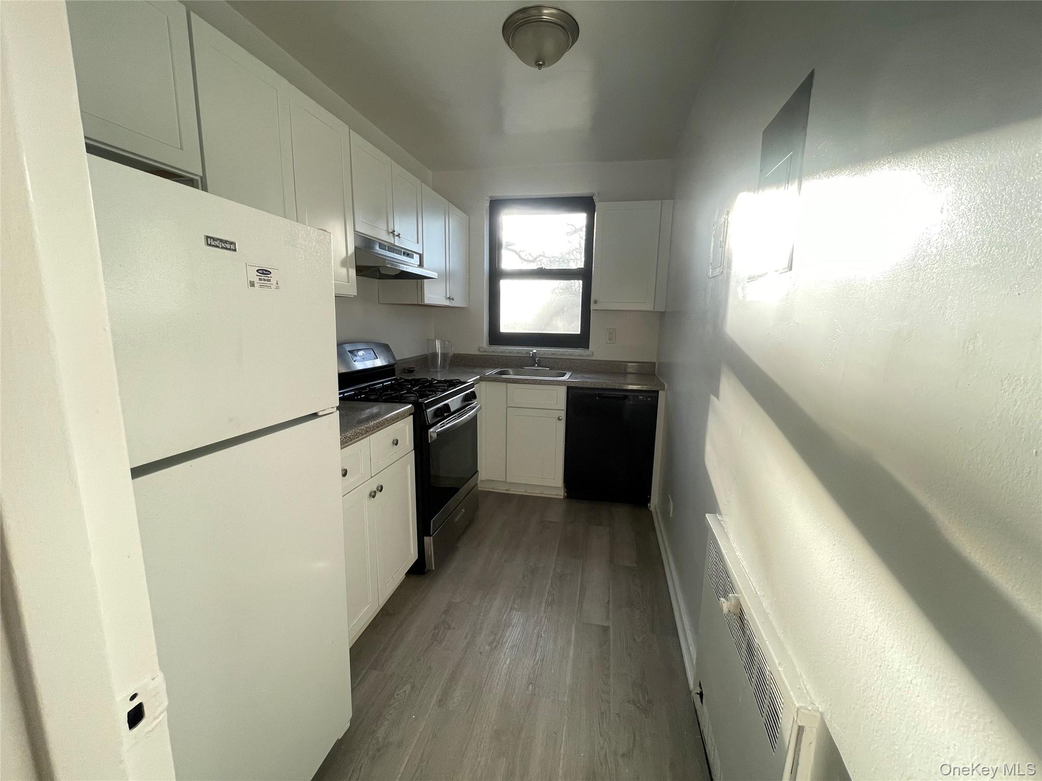 141 East Hartsdale Avenue, Unit 2A Hartsdale, NY 10530 - Photo 7 of 24 Kitchen featuring freestanding refrigerator, gas stove, white cabinetry, dishwasher, and dark wood-style floors