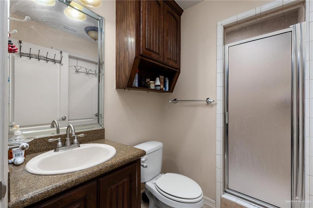 2101 Happy Street Mission, TX 78573 - Photo 12 of 20 a bathroom with a granite countertop sink toilet and mirror