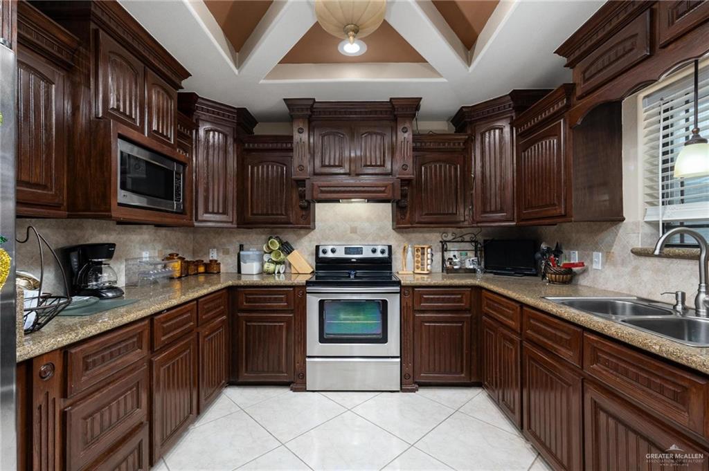 2101 Happy Street Mission, TX 78573 - Photo 4 of 20 a kitchen with stainless steel appliances granite countertop a stove sink microwave and cabinets