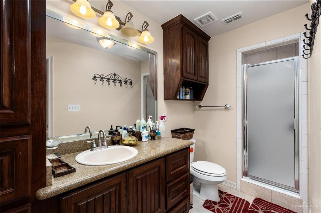 2101 Happy Street Mission, TX 78573 - Photo 9 of 20 a bathroom with a toilet a sink and mirror