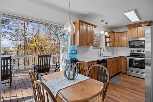 a kitchen with a sink a window and chairs