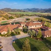 an aerial view of a house with a mountain
