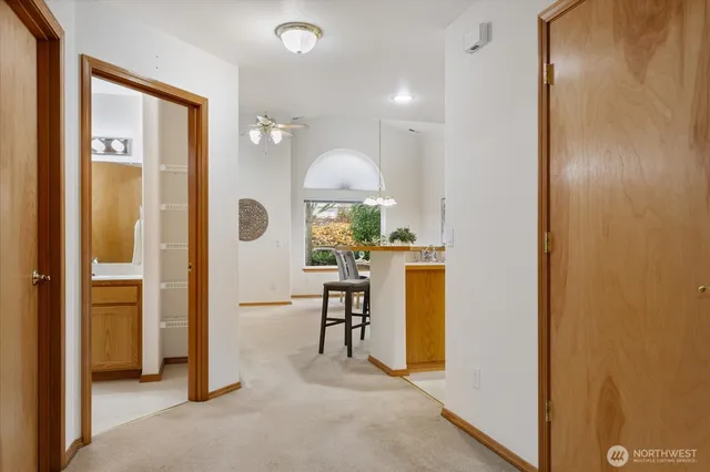 a view of a hallway with furniture and a refrigerator