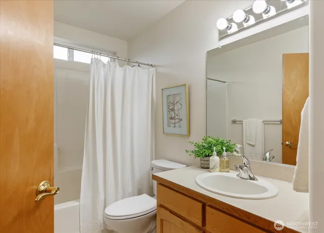 a bathroom with a sink vanity mirror and toilet