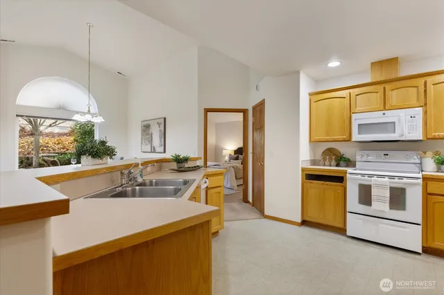 a kitchen with stainless steel appliances granite countertop a sink a stove and a refrigerator