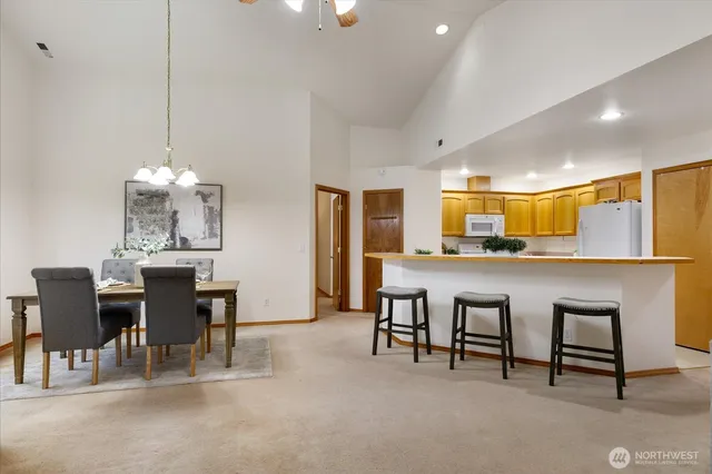 a dining room with furniture a chandelier and kitchen view