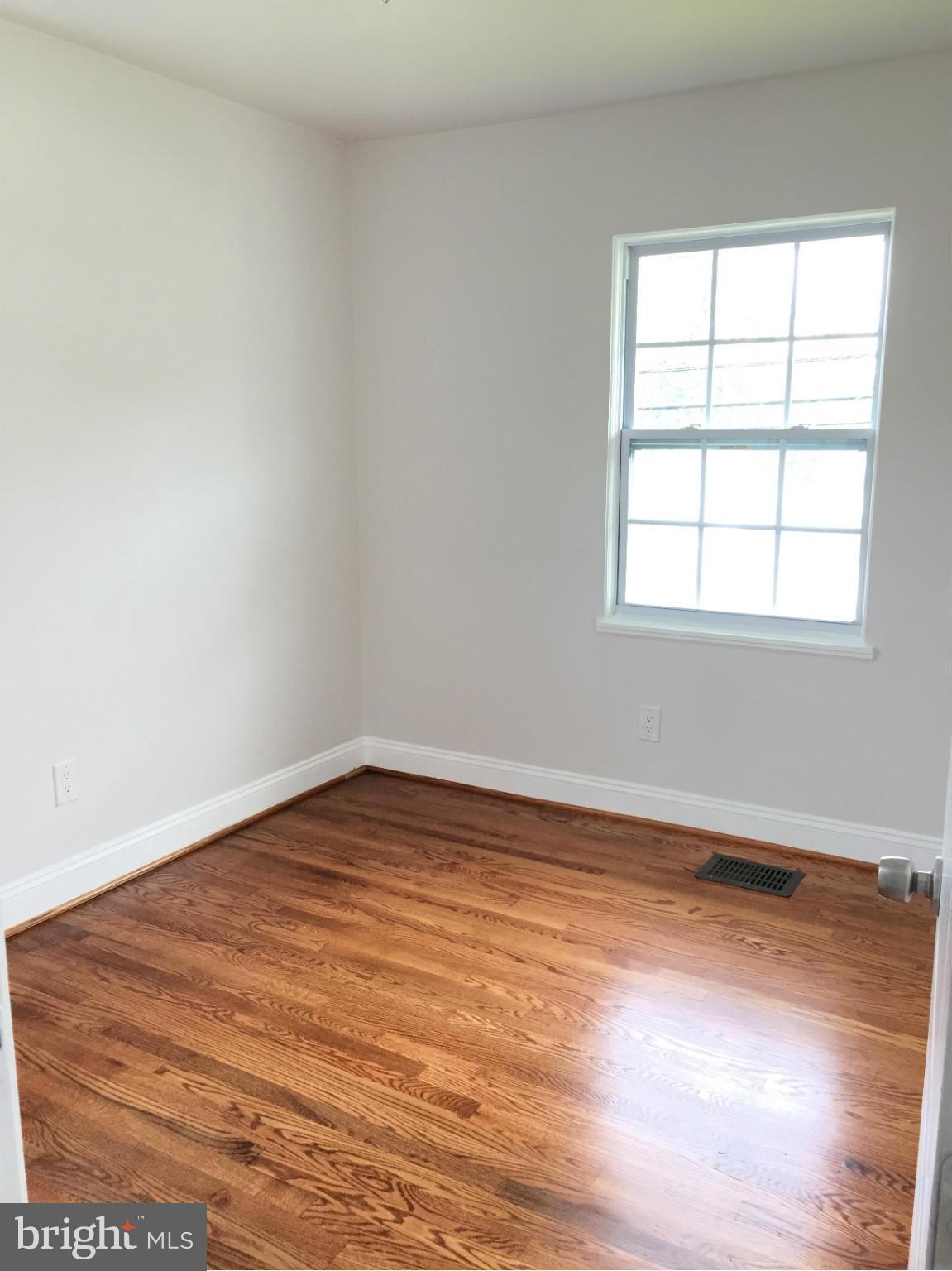 5705 Westgate Road Lanham, MD 20706 - Photo 14 of 26 an empty room with wooden floor and windows