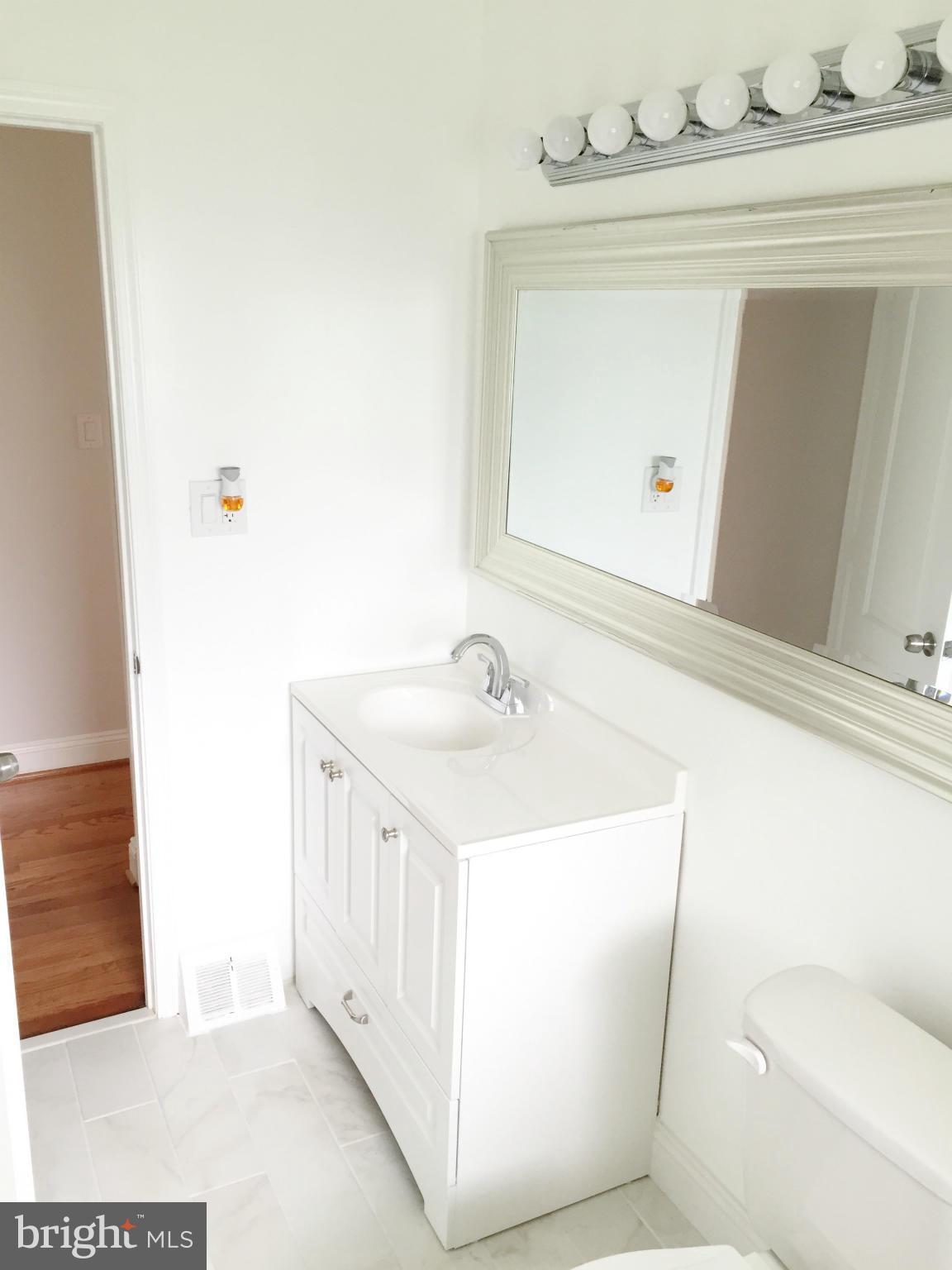 5705 Westgate Road Lanham, MD 20706 - Photo 8 of 26 a bathroom with a sink a toilet and mirror