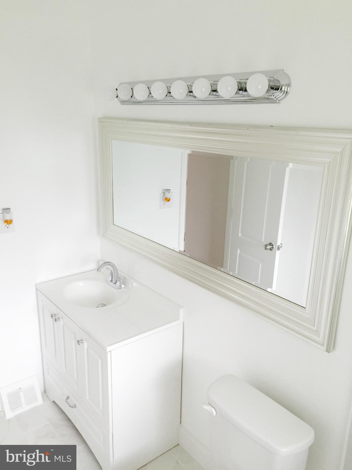 5705 Westgate Road Lanham, MD 20706 - Photo 9 of 26 a bathroom with a sink a toilet and mirror