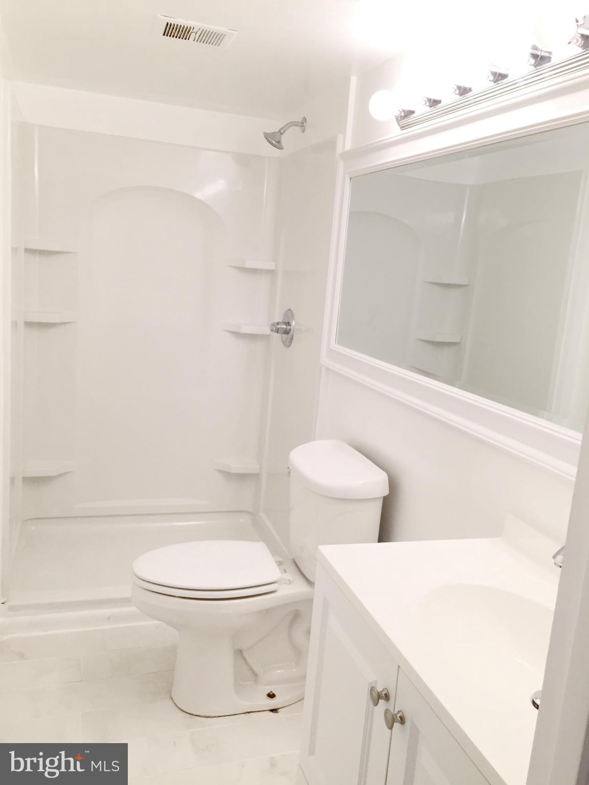 5705 Westgate Road Lanham, MD 20706 - Photo 10 of 26 a white toilet sitting next to a bathroom sink