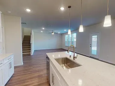 a kitchen with a sink cabinets and wooden floor