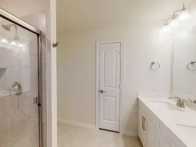 a bathroom with a double vanity sink mirror and shower