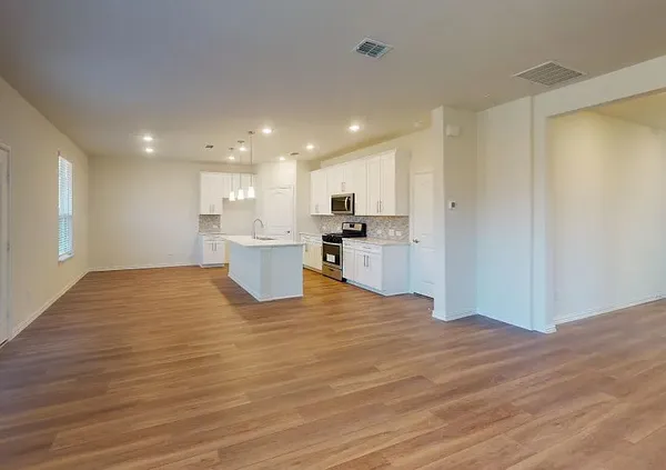 a view of a kitchen with a sink and wooden cabinets