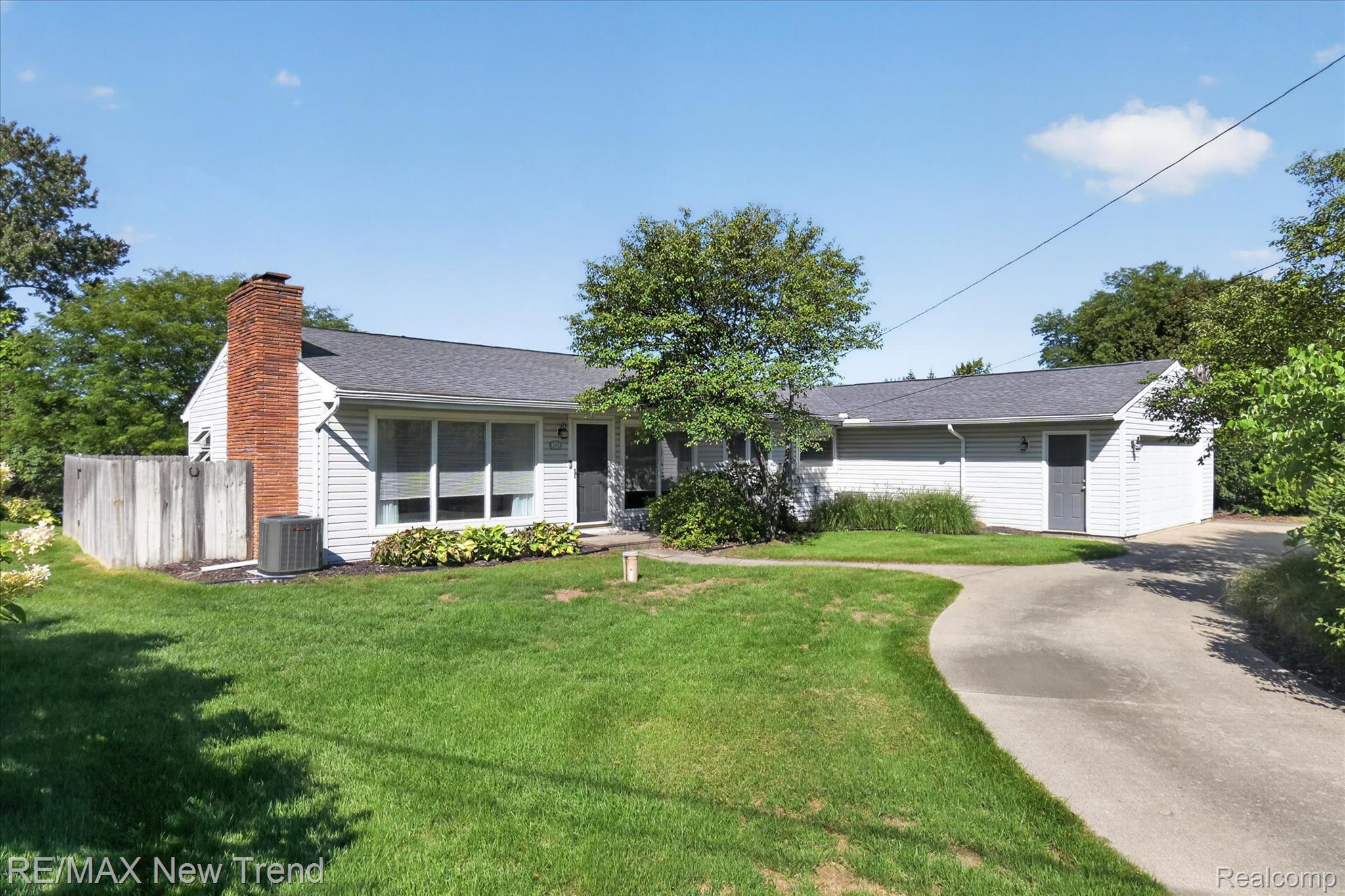 2529 South Commerce Road Walled Lake, MI 48390 - Photo 1 of 66 Ranch-style exterior with light-toned siding, a brick chimney, and a dark shingle roof