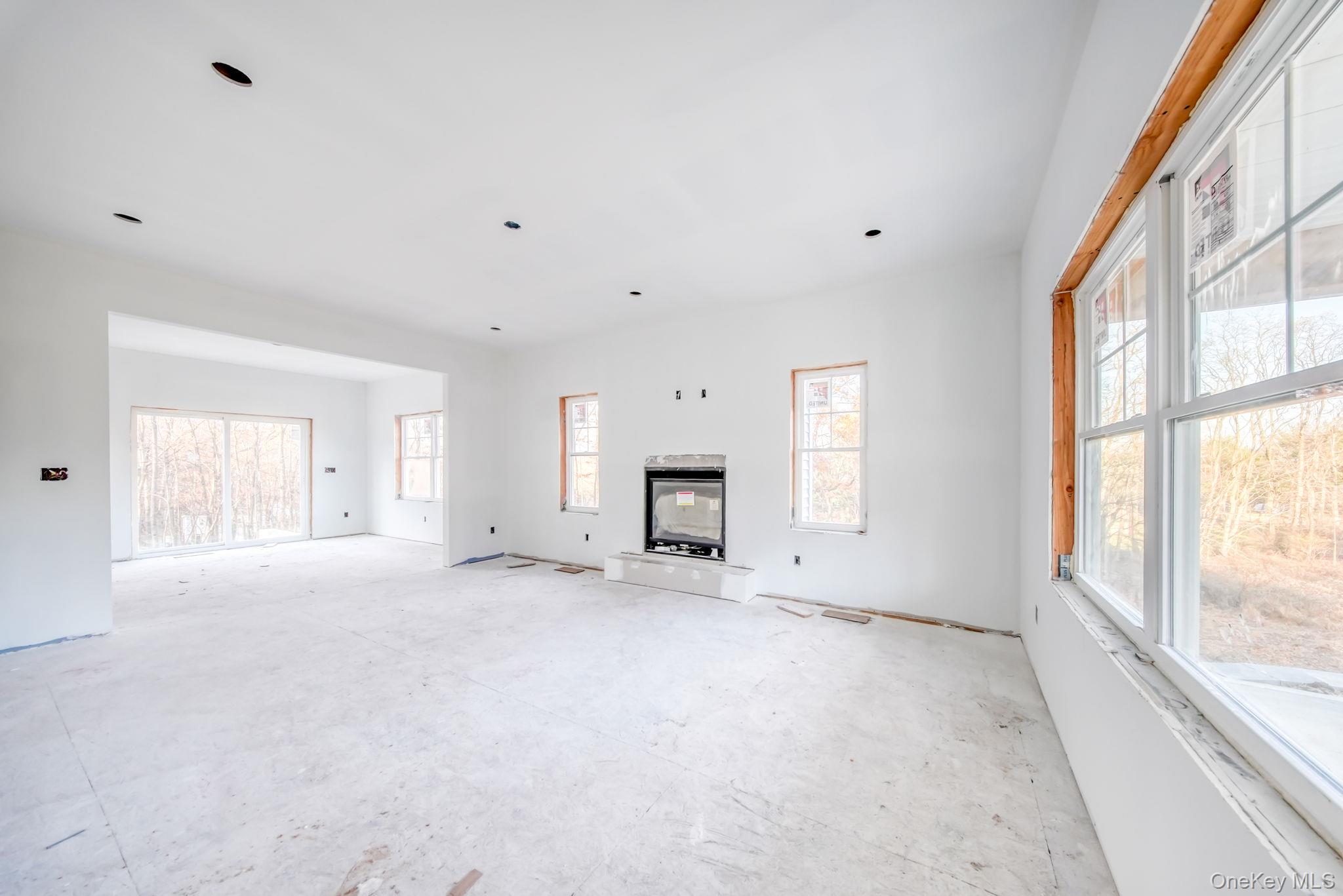 48 West Corbett Road Montgomery, NY 12549 - Photo 11 of 38 Unfurnished living room with healthy amount of natural light and a multi sided fireplace