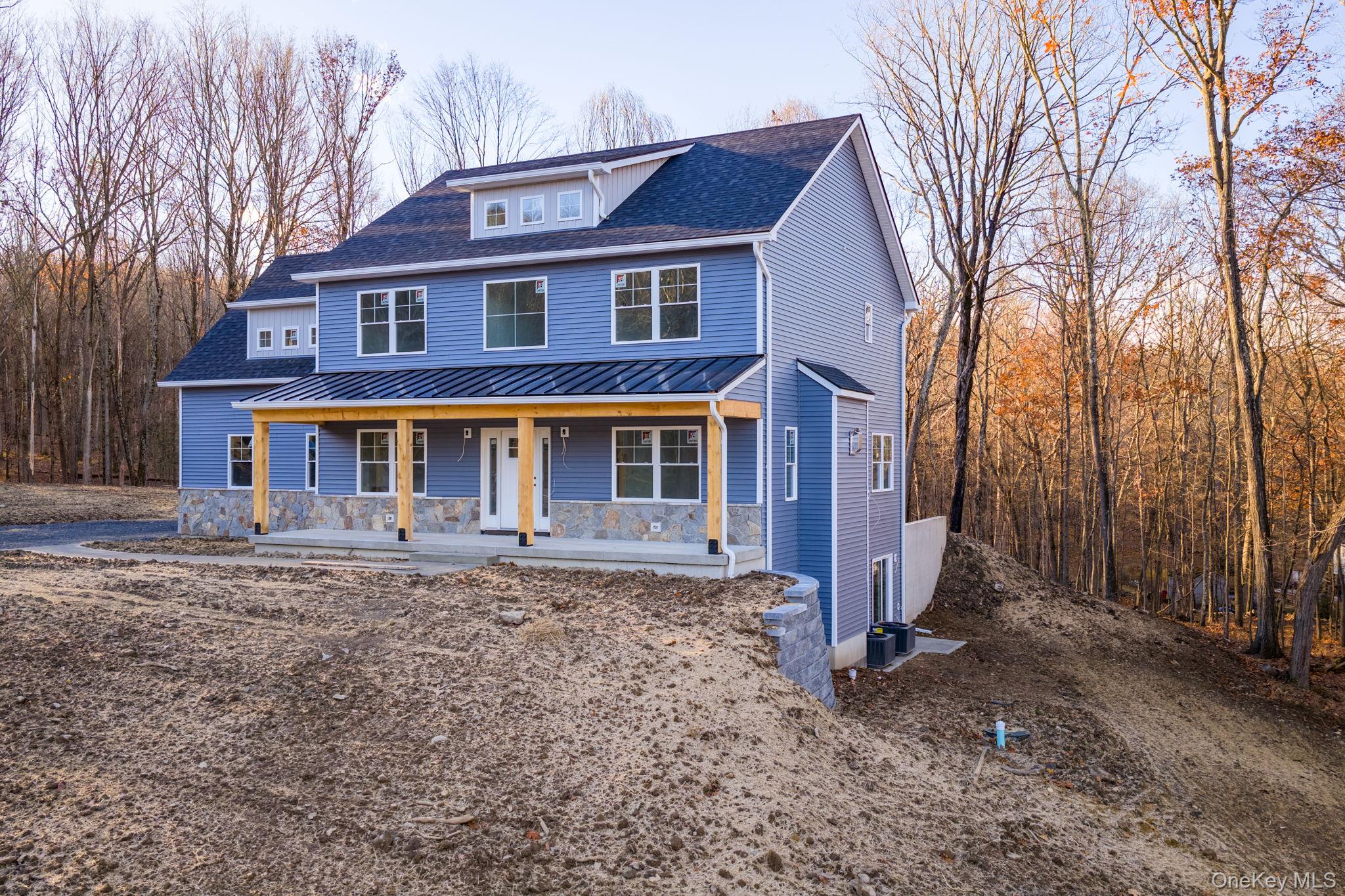48 West Corbett Road Montgomery, NY 12549 - Photo 3 of 38 View of front facade featuring covered porch, roof with shingles, a standing seam roof, a view of trees, and a metal roof
