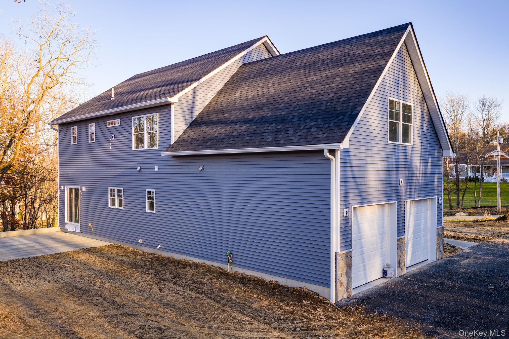 48 West Corbett Road Montgomery, NY 12549 - Photo 38 of 38 View of property exterior with roof with shingles, a garage, and a patio area