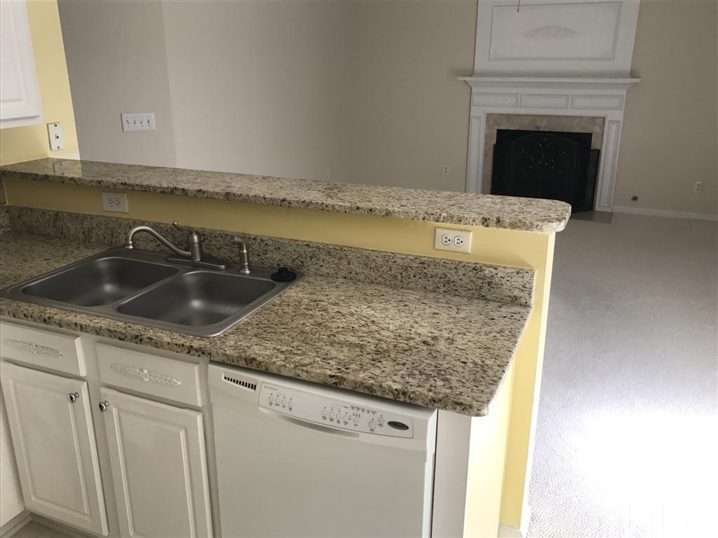 4528 Drewbridge Way Raleigh, NC 27604 - Photo 10 of 25 a kitchen with granite countertop a sink and cabinets