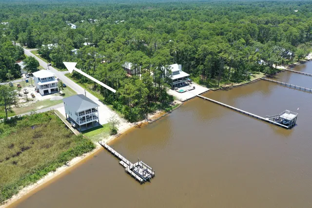 an aerial view of a house with a yard and lake view