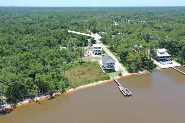 an aerial view of a house with a yard and lake view