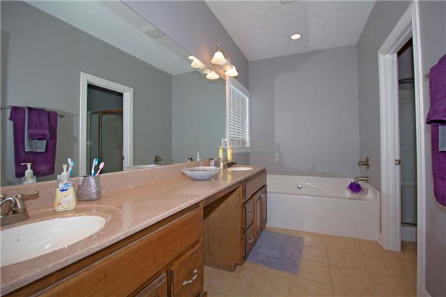 259 Aplin Branch Road Cottontown, TN 37048 - Photo 11 of 19 a bathroom with a granite countertop sink a large mirror and a bathtub