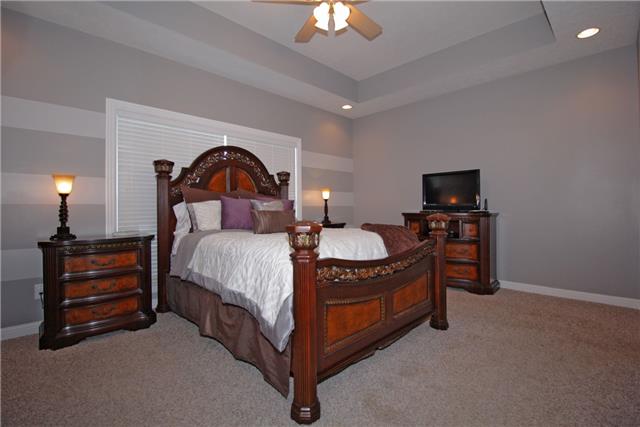 259 Aplin Branch Road Cottontown, TN 37048 - Photo 10 of 19 a spacious bedroom with a bed and a chandelier
